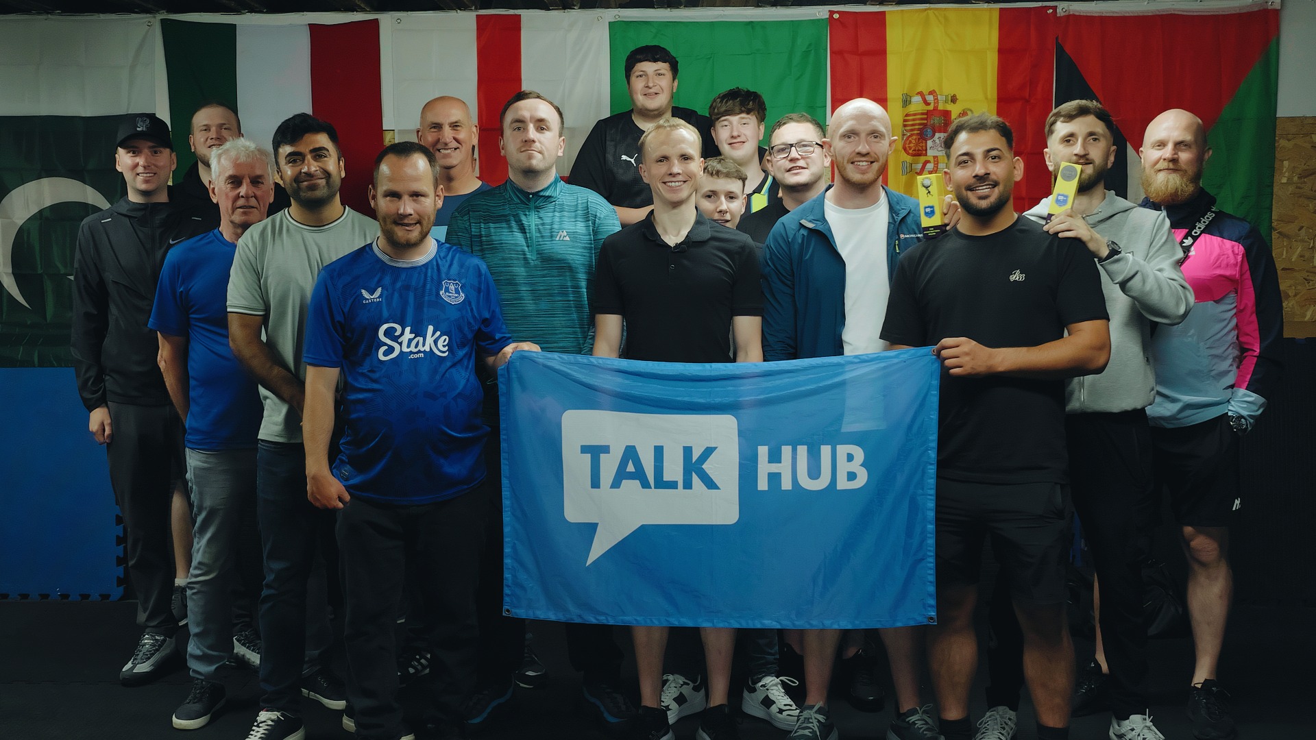 TalkHub members together in the boxing gym holding a TalkHub banner